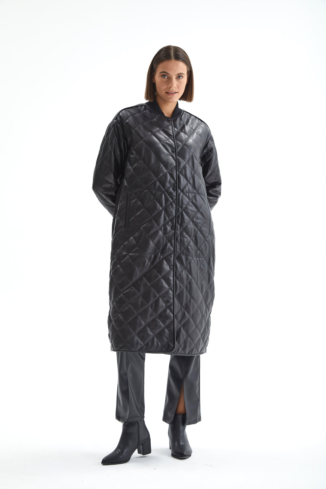Full-length view of the Kensington black leather coat showing its relaxed silhouette and diamond quilting.