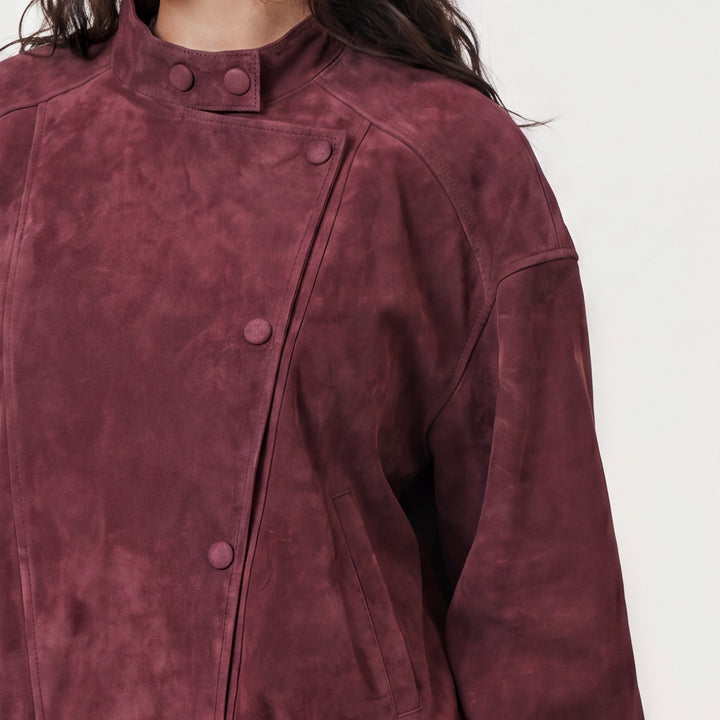 Close-up burgundy suede jacket snap buttons and texture detail