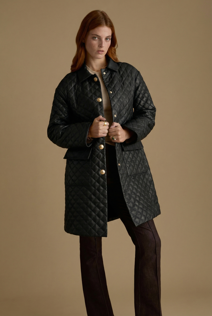 Woman wearing Holland black quilted leather coat with gold-tone buttons by FURNIQ UK