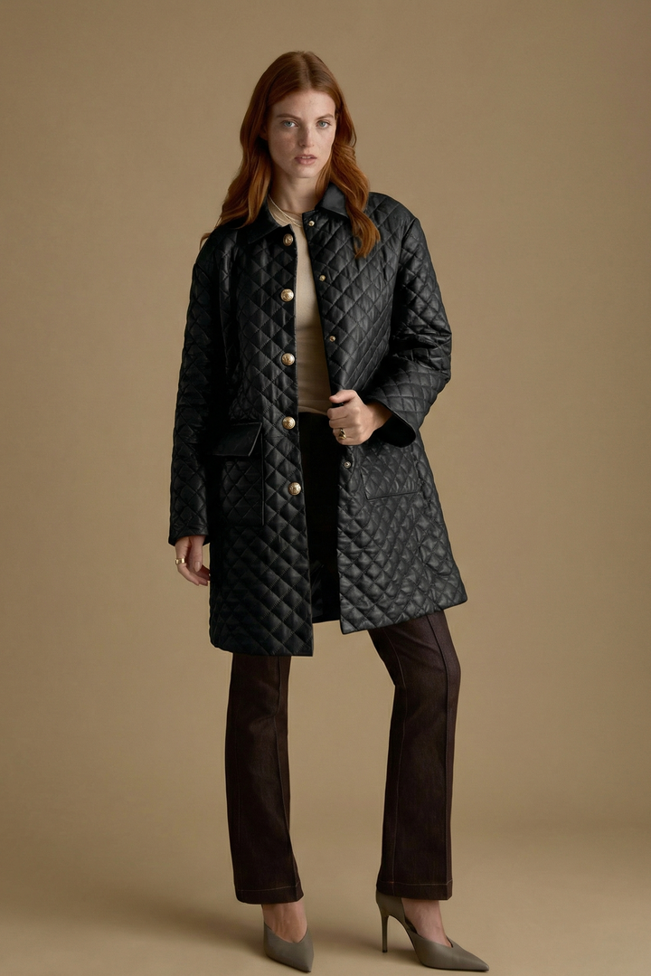 Full-length Holland black quilted leather coat styled with tailored brown trousers