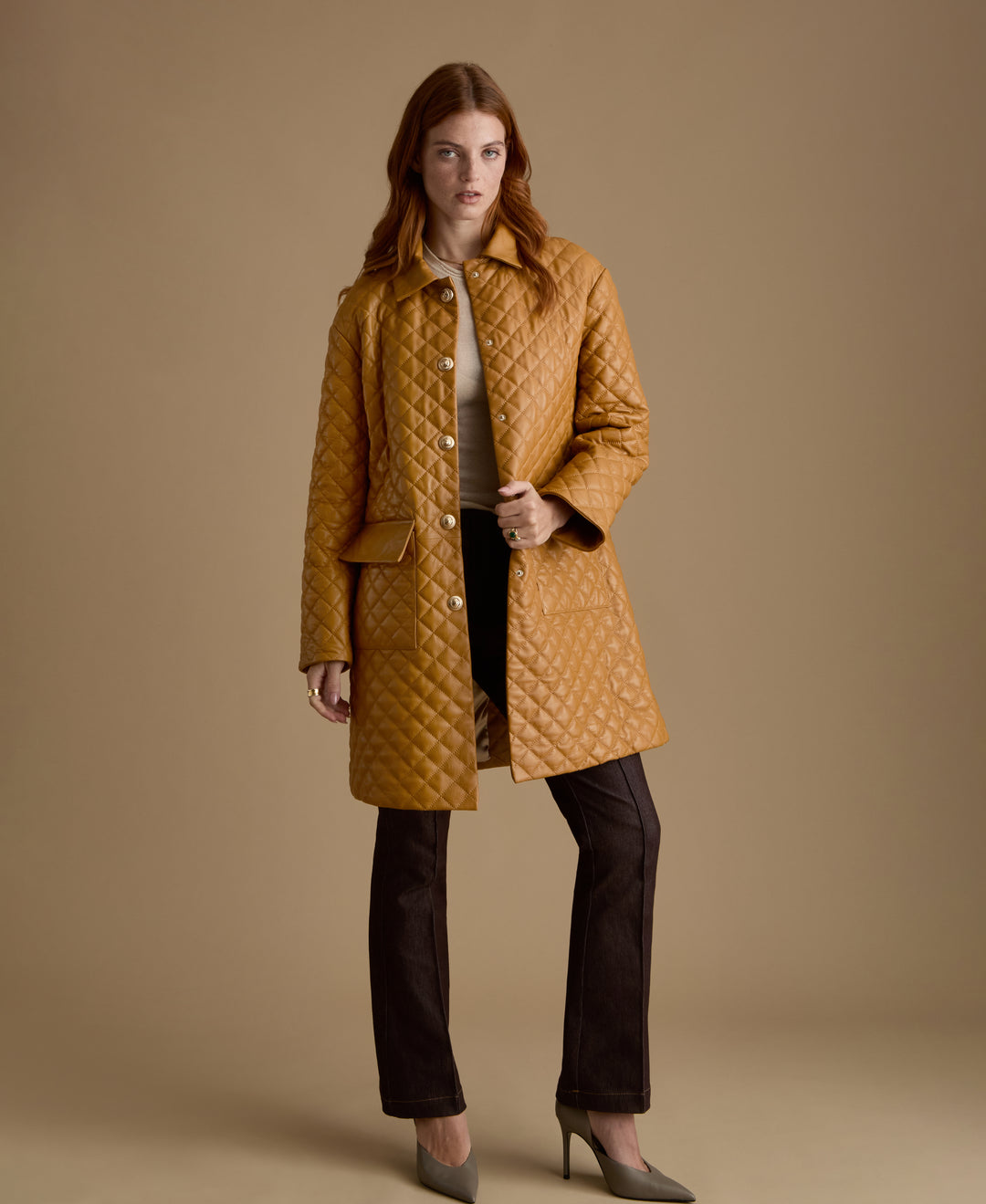 Woman wearing Holland caramel quilted leather coat with gold-tone buttons by FURNIQ UK