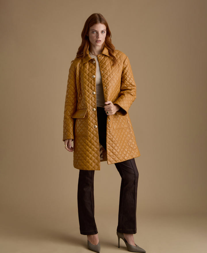 Woman wearing Holland caramel quilted leather coat with gold-tone buttons by FURNIQ UK