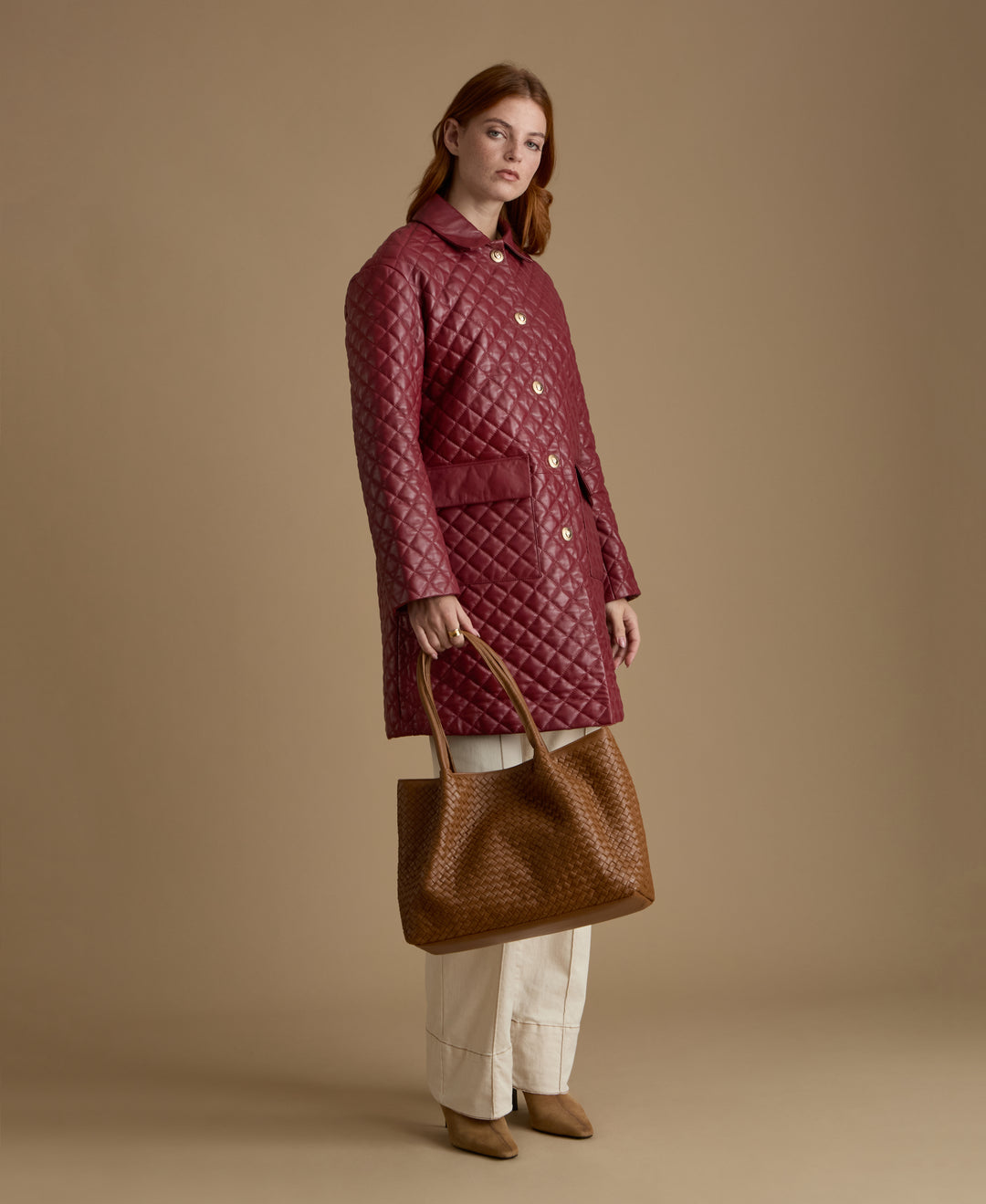 Holland light burgundy quilted leather coat styled with cream tailoring and woven leather handbag