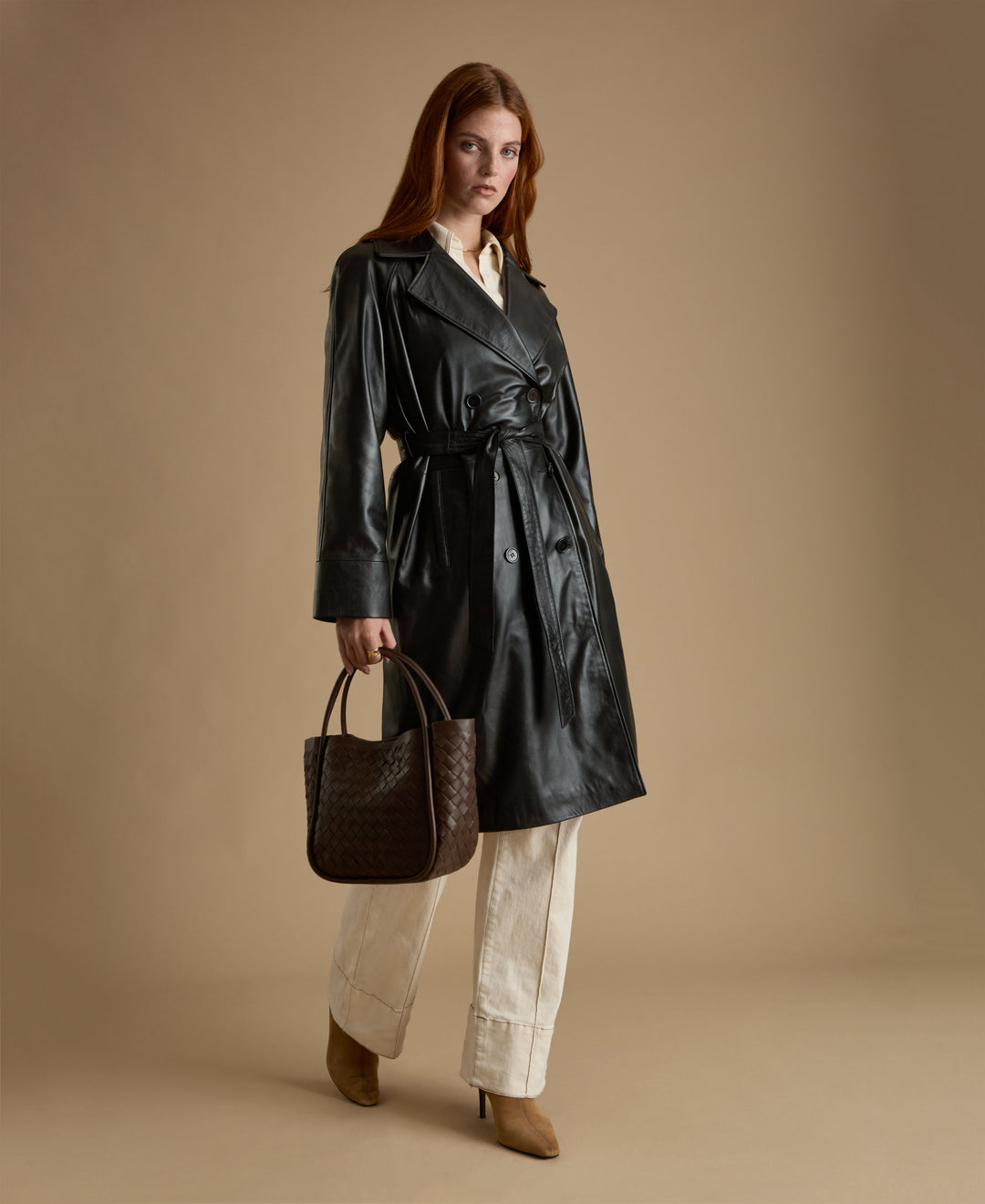 Sloane black leather trench coat belted leather coat styled with brown woven bag