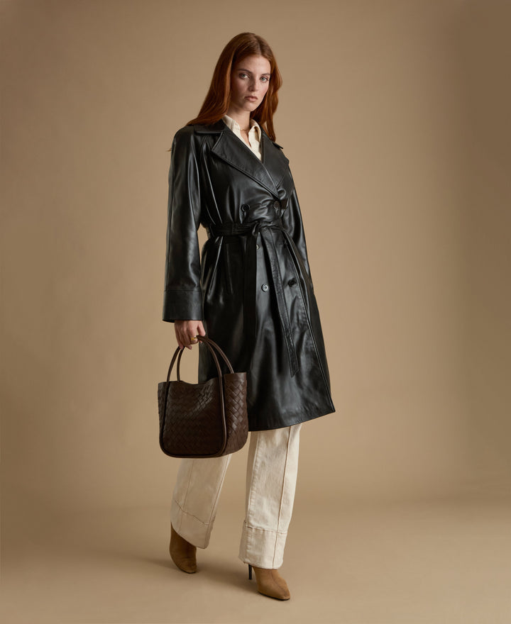 Sloane black leather trench coat belted leather coat styled with brown woven bag