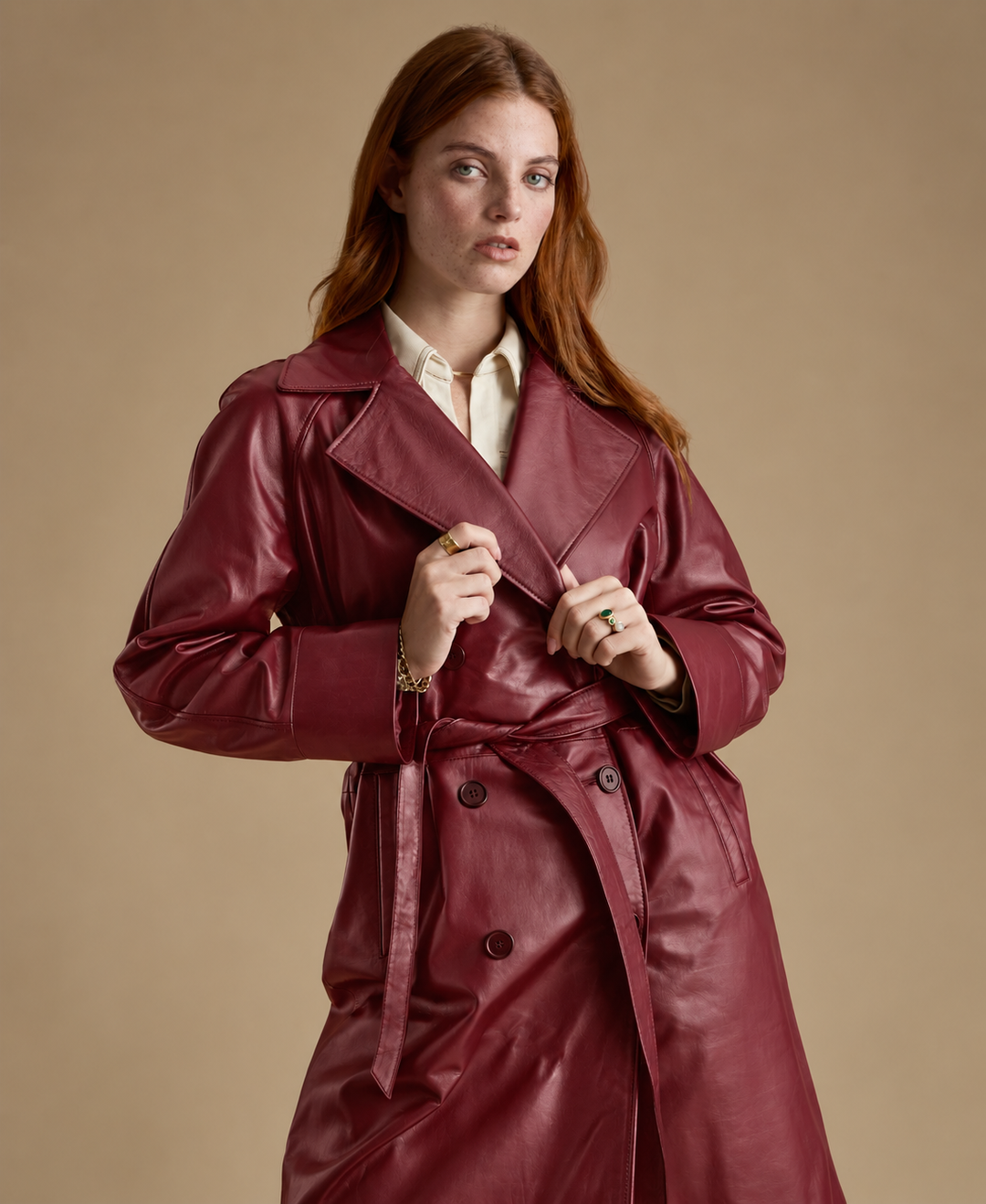 Sloane burgundy leather trench coat showing wide lapels, double-breasted front and leather belt