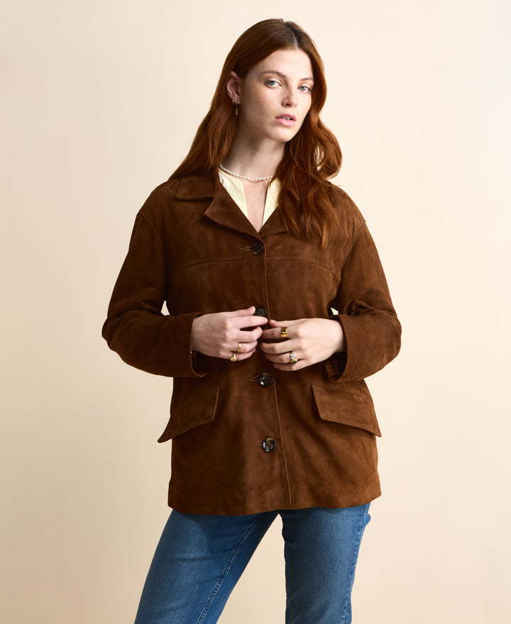 Front view of the Vera chestnut brown suede jacket worn closed with a cream blouse and blue jeans.